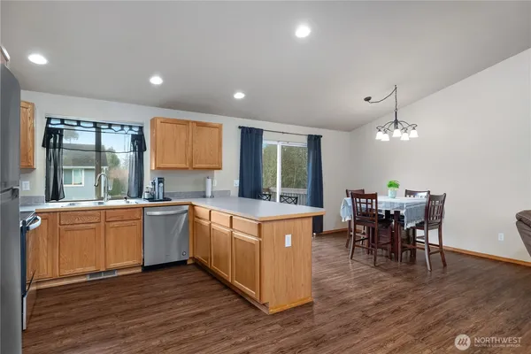 a kitchen with stainless steel appliances granite countertop wooden floors and white cabinets