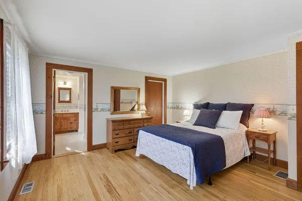 a bedroom with a large bed and a chandelier