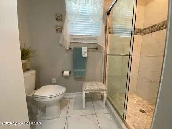 a bathroom with a toilet and a shower