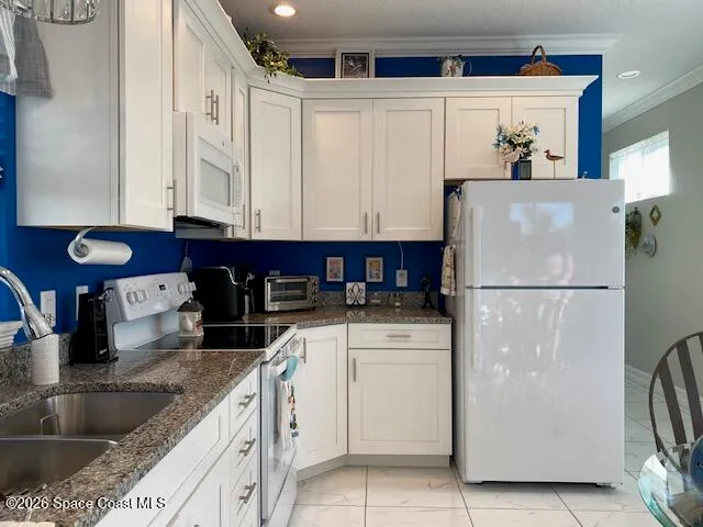 a kitchen with stainless steel appliances granite countertop a refrigerator sink and white cabinets