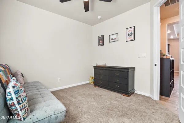 a living room with baby crib furniture and a window