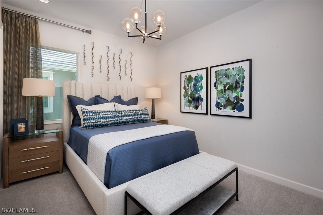 6181 Megans Bay Drive Naples, FL 34113 - Photo 11 of 32 a bedroom with a bed chandelier and a window