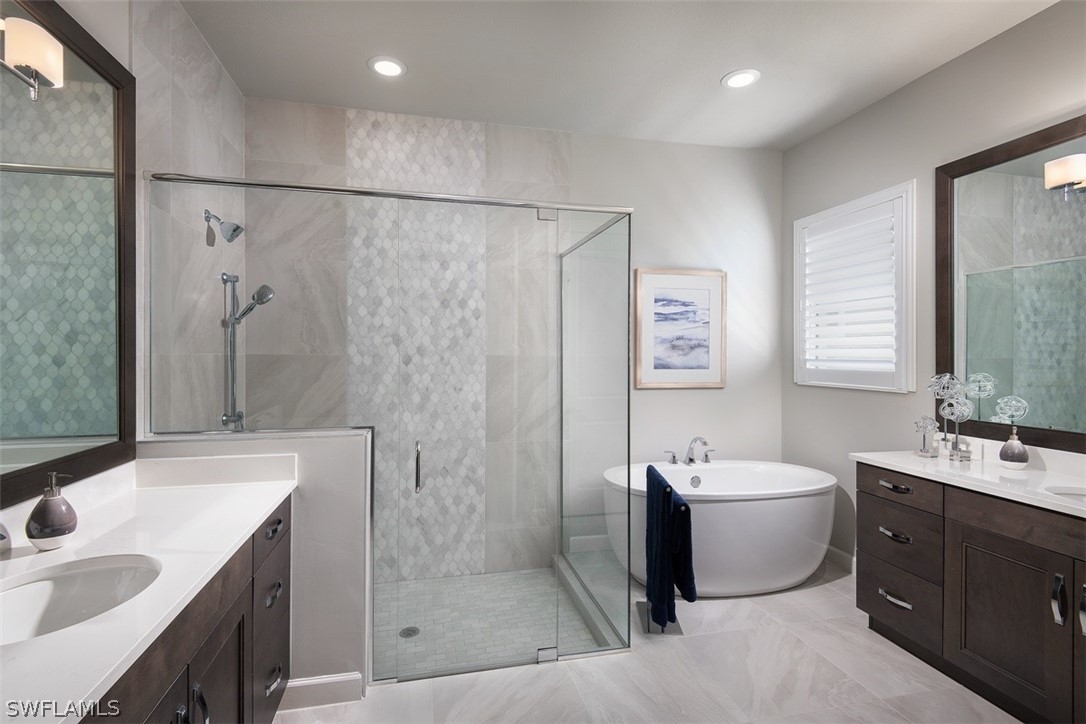 6181 Megans Bay Drive Naples, FL 34113 - Photo 13 of 32 a bathroom with a double vanity sink toilet and shower
