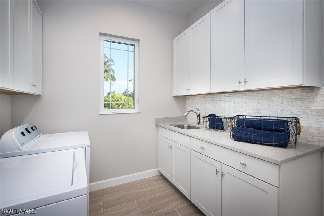 6181 Megans Bay Drive Naples, FL 34113 - Photo 14 of 32 a kitchen with cabinets appliances a sink and a window