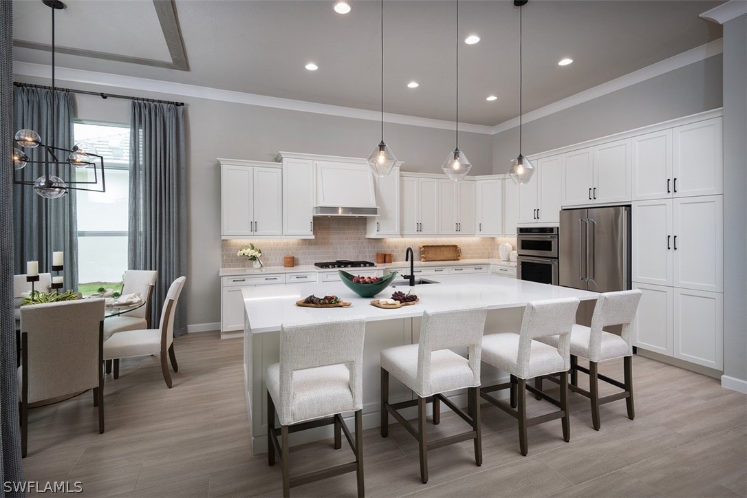 6181 Megans Bay Drive Naples, FL 34113 - Photo 2 of 32 a kitchen with a dining table chairs and refrigerator