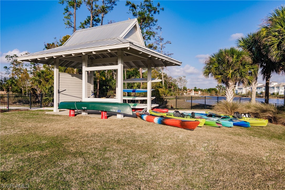 6181 Megans Bay Drive Naples, FL 34113 - Photo 30 of 32 an outdoor space with chairs and umbrella