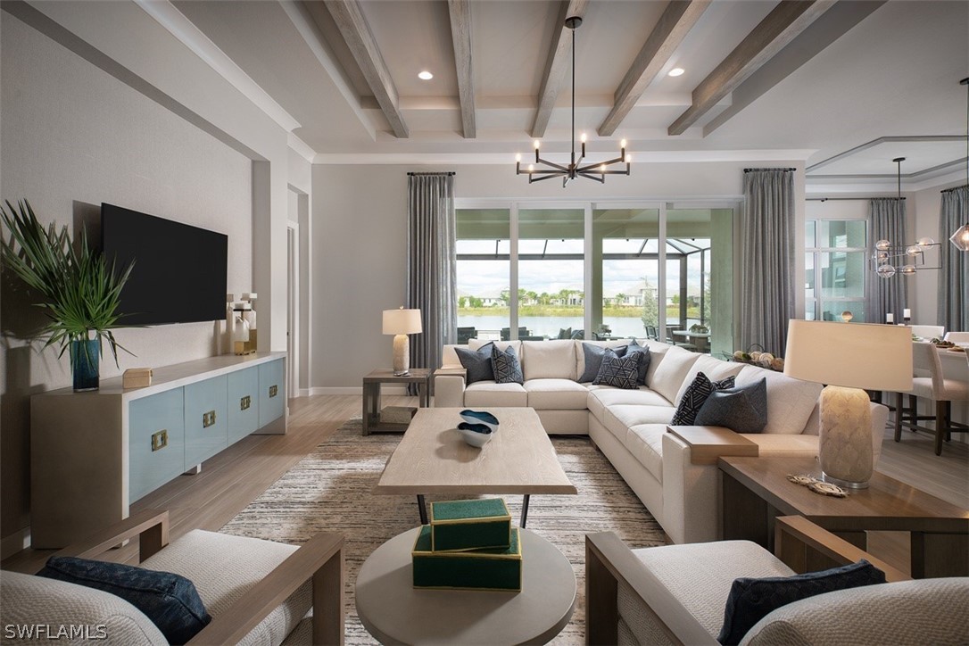 6181 Megans Bay Drive Naples, FL 34113 - Photo 5 of 32 a living room with furniture a flat screen tv and a large window