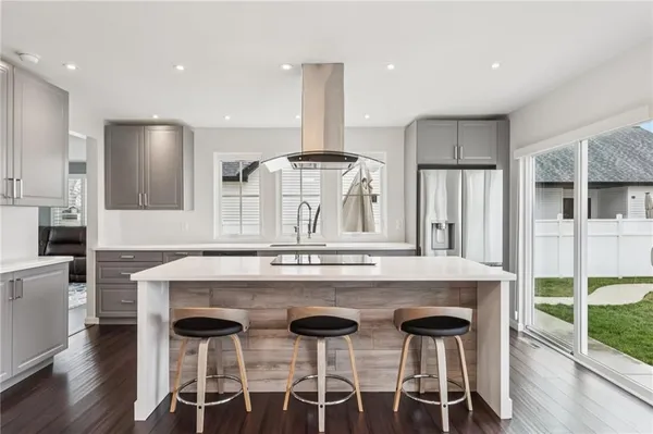 a kitchen with stainless steel appliances kitchen island a stove a table and chairs