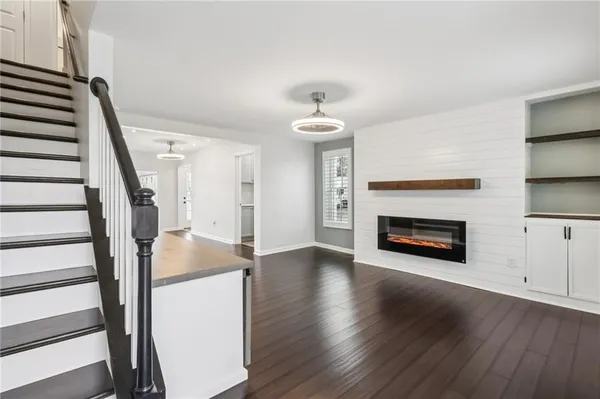 a view of a livingroom with wooden floor and a fireplace