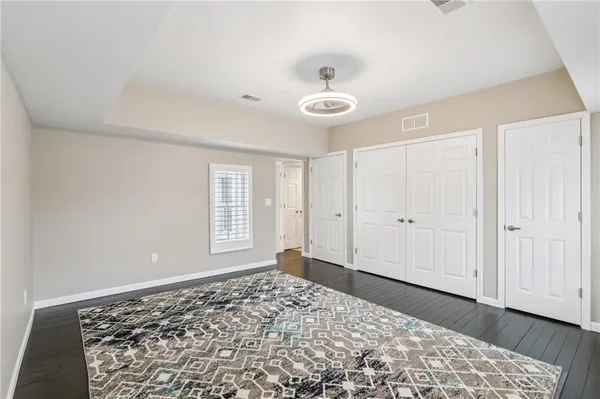 a view of a room with a bed and wooden floor