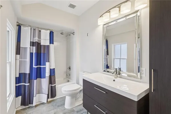 a bathroom with a double vanity sink toilet and shower
