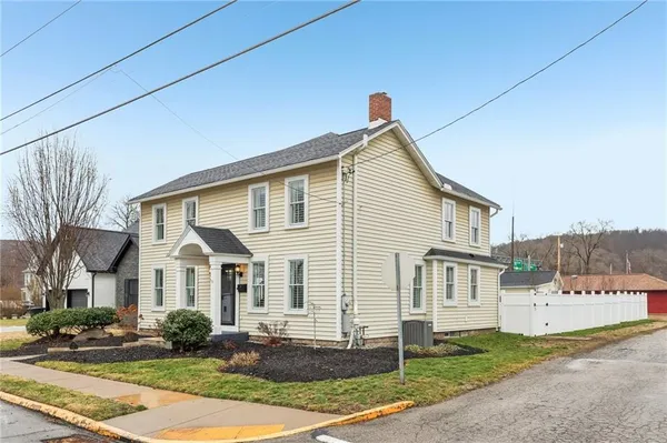 a view of a white house with large windows and a yard