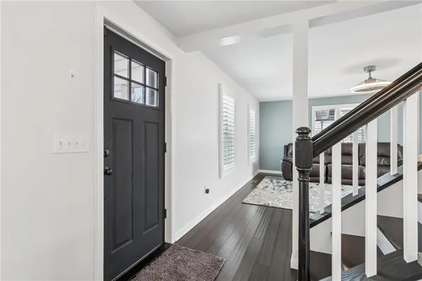 a view of an entryway with wooden floor and stairs