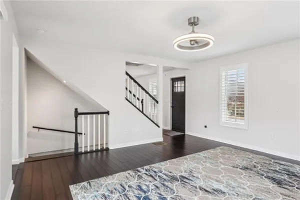 a view of a livingroom with wooden floor and a ceiling fan
