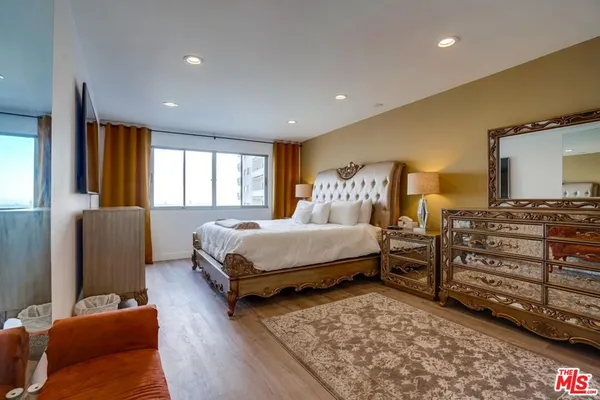 a bedroom with a bed and wooden floor