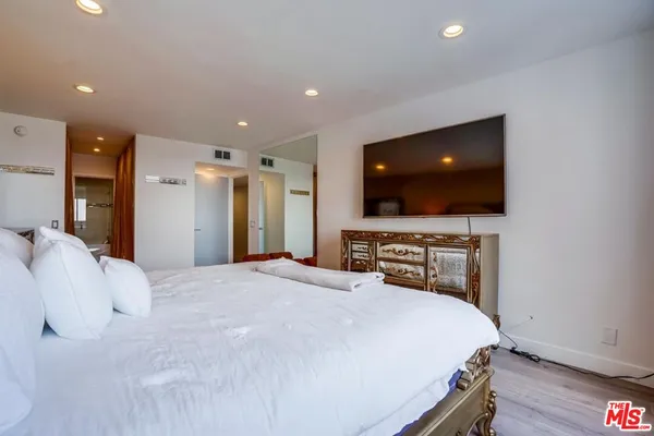 a bedroom with a bed and a flat screen tv