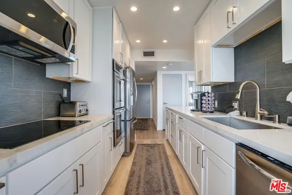 a kitchen with stainless steel appliances granite countertop a sink and a stove