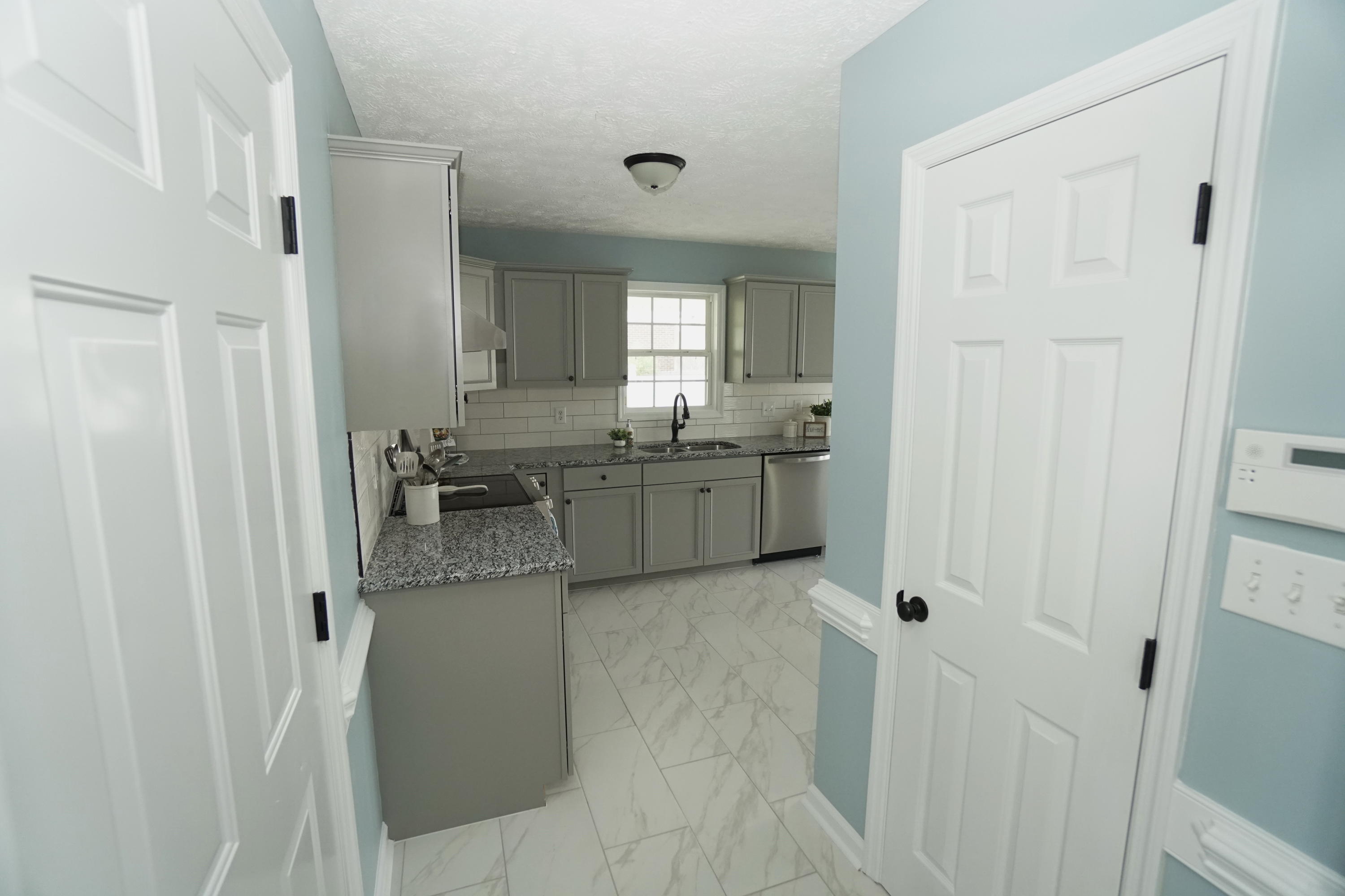 107 Cherian Court Pooler, GA 31322 - Photo 8 of 50 Entering the kitchen from the dining room. Pantry door is on the right; door leading to the garage is on the left.