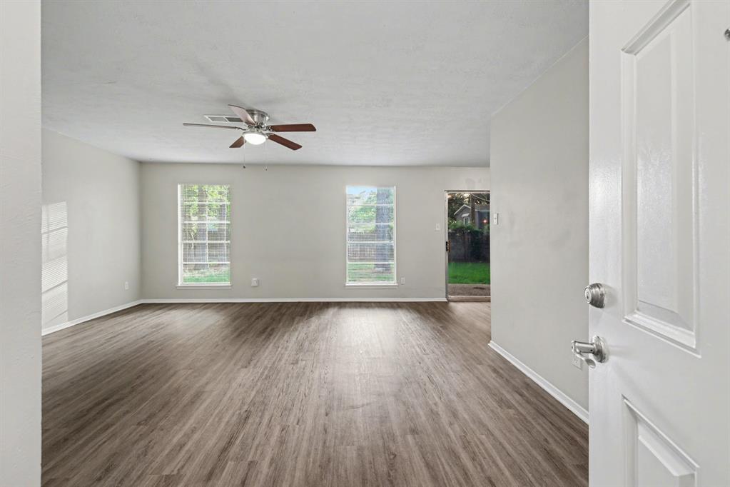 1321 North 7th Street Conroe, TX 77301 - Photo 6 of 17 a view of an empty room with wooden floor and a window