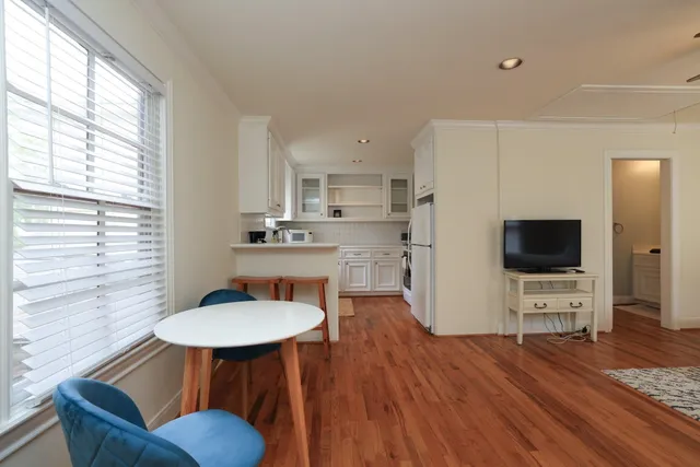 a living room with furniture a flat screen tv and a large window