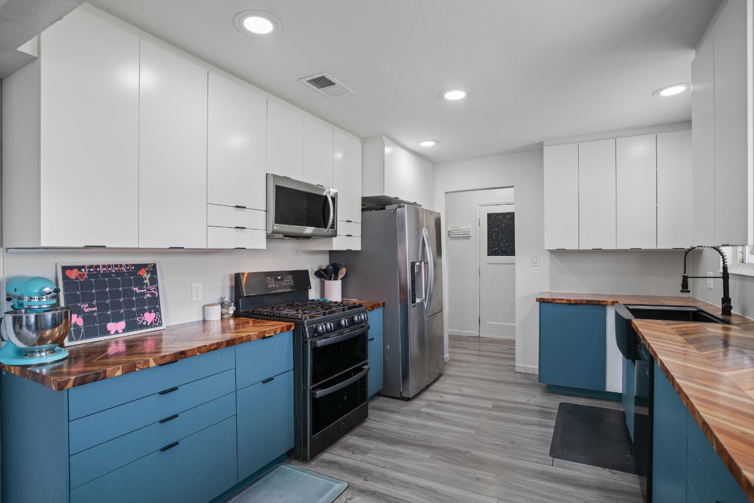 832 Jackson Street Winters, CA 95694 - Photo 9 of 41 two tone kitchen with two tone color scheme, butcher block counters, stainless steel appliances, modern cabinets, and recessed lighting