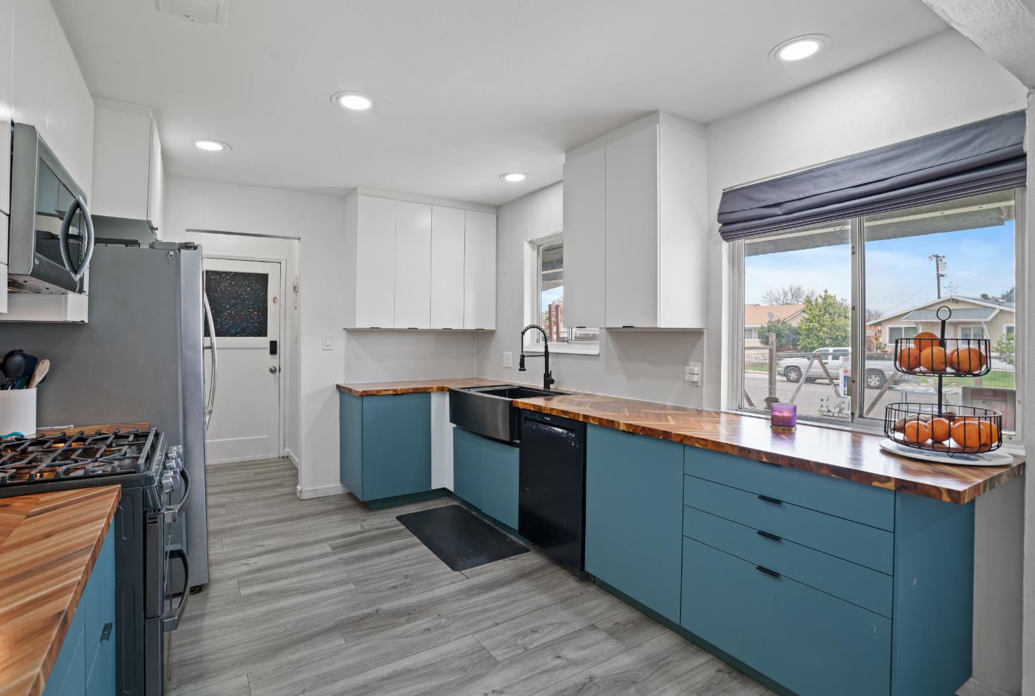 832 Jackson Street Winters, CA 95694 - Photo 10 of 41 two tone kitchen with two tone cabinets, wooden counters, stainless steel appliances, light wood-style flooring, and recessed lighting