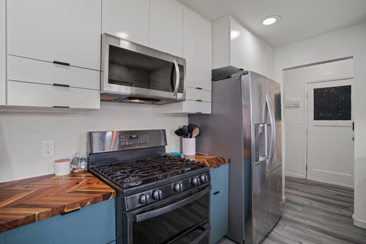 832 Jackson Street Winters, CA 95694 - Photo 11 of 41 kitchen featuring butcher block countertops, stainless steel appliances, two tone cabinets, modern cabinets, and light wood-style floors