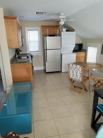 a kitchen with a refrigerator and white cabinets