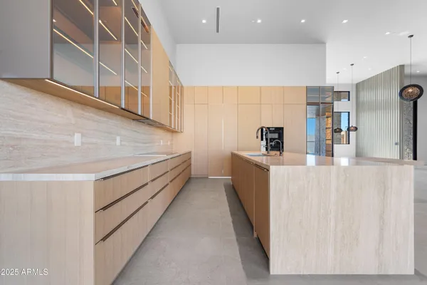 a kitchen with stainless steel appliances granite countertop a stove and a view of living room