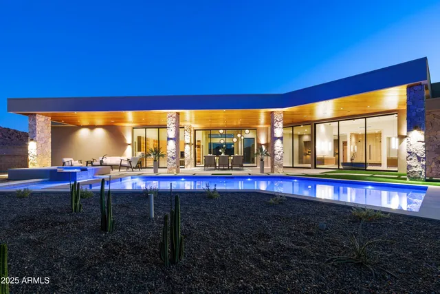 a view of a swimming pool with a table and chairs under an umbrella