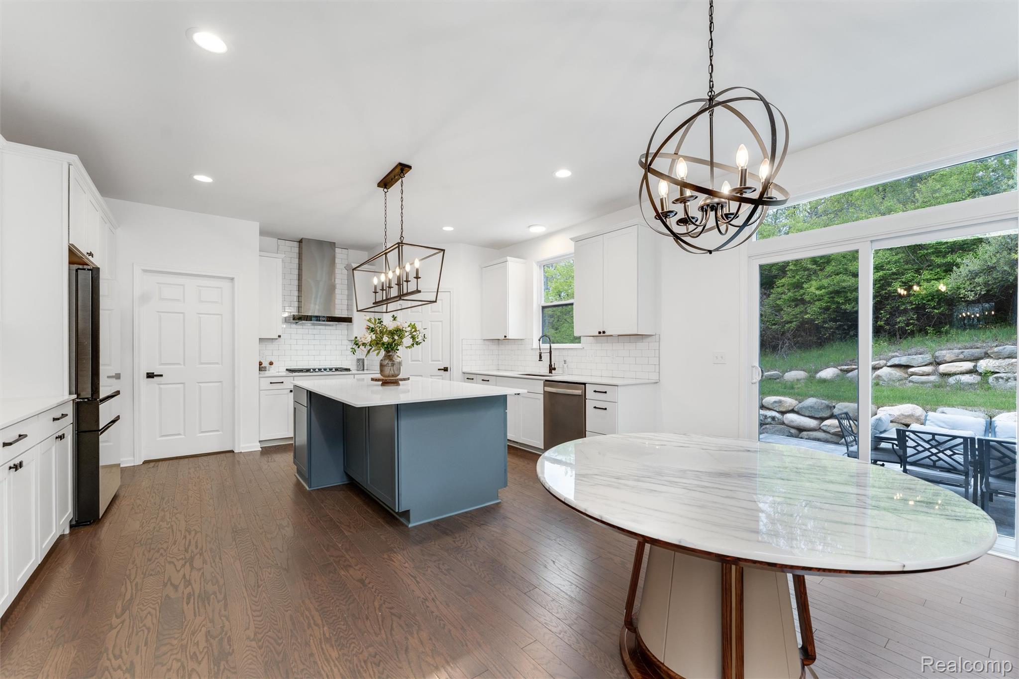 908 South Livernois Road Rochester, MI 48309 - Photo 8 of 49 Kitchen with a chandelier, a center island, dark wood-style flooring, two tone color scheme, and backsplash