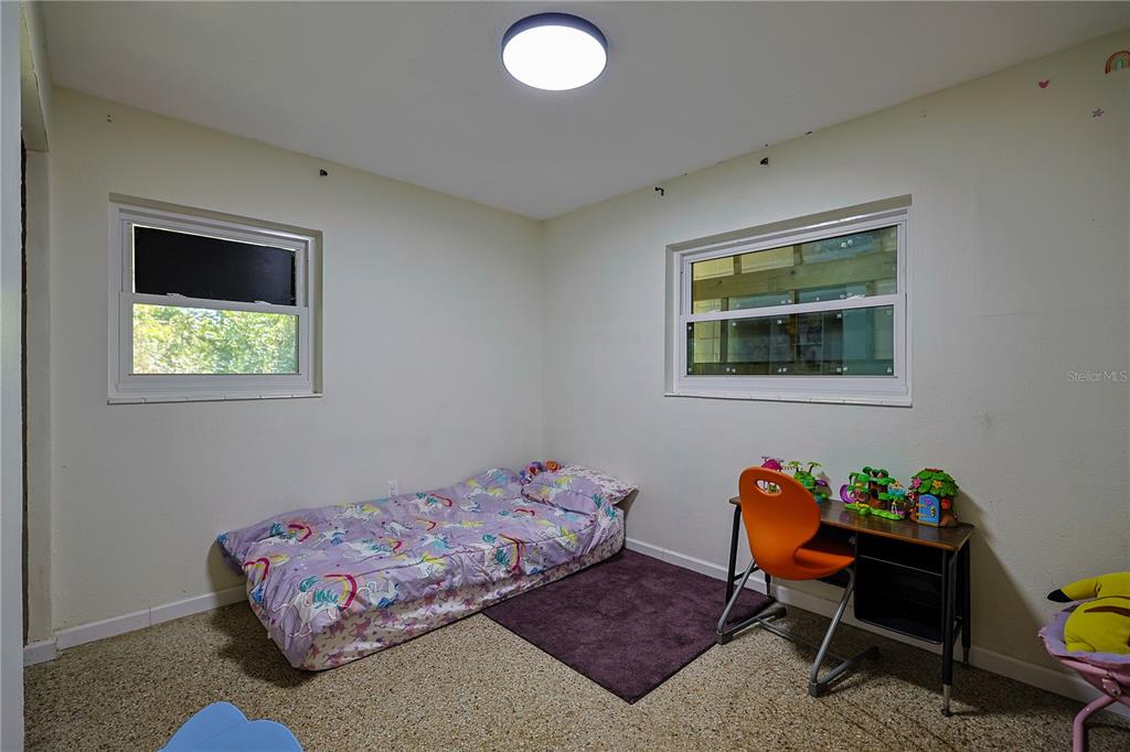 613 Scenic Street Leesburg, FL 34748 - Photo 16 of 38 a bedroom with a bed and a desk