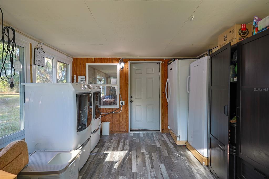 613 Scenic Street Leesburg, FL 34748 - Photo 25 of 38 a view of a kitchen with fridge and wooden floor