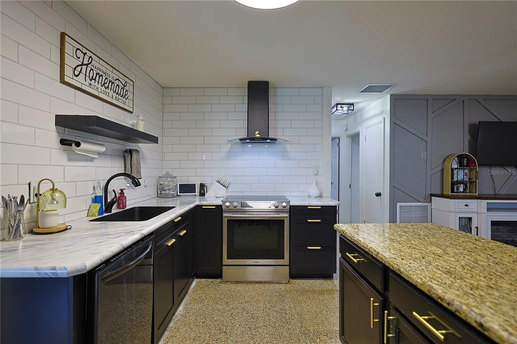 613 Scenic Street Leesburg, FL 34748 - Photo 6 of 38 a kitchen with stainless steel appliances granite countertop a sink stove and refrigerator