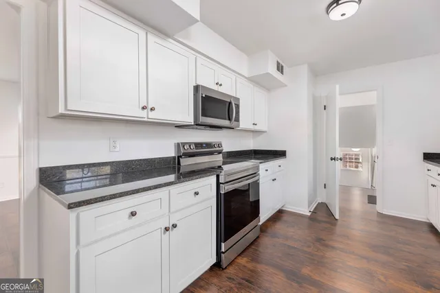 a kitchen with white cabinets and stainless steel appliances