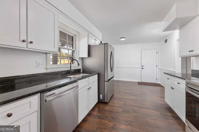 a kitchen with stainless steel appliances granite countertop a refrigerator and a sink