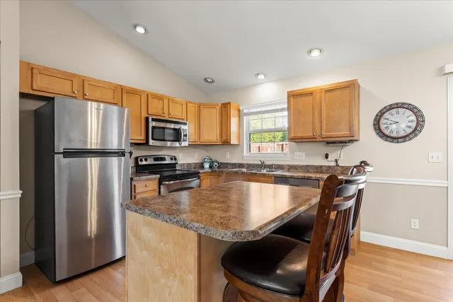 a kitchen with granite countertop a refrigerator a stove a sink a washer and a refrigerator