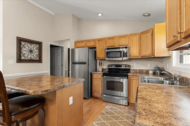a kitchen with granite countertop a refrigerator stove and microwave