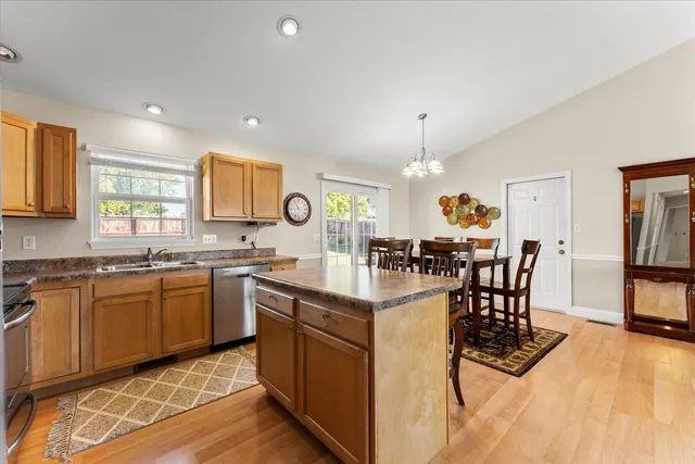 a kitchen with stainless steel appliances granite countertop a table and chairs in it