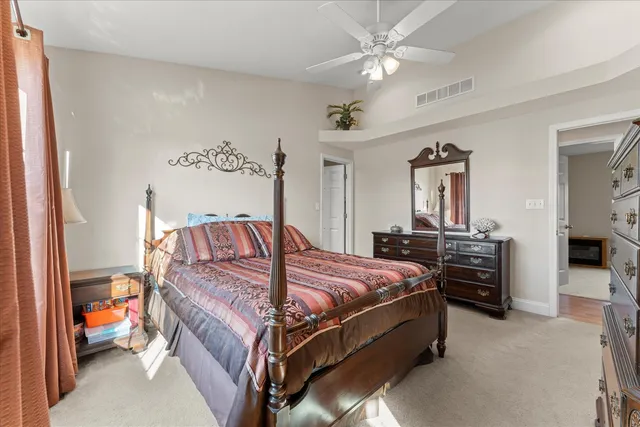 a bedroom with a bed and dresser with mirror