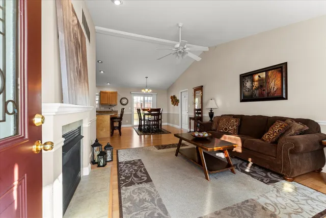a living room with furniture a fireplace and a chandelier