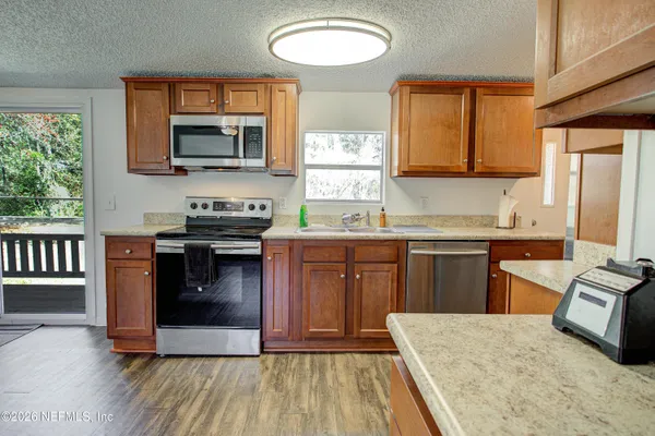 a kitchen with stainless steel appliances granite countertop a stove a sink and a microwave