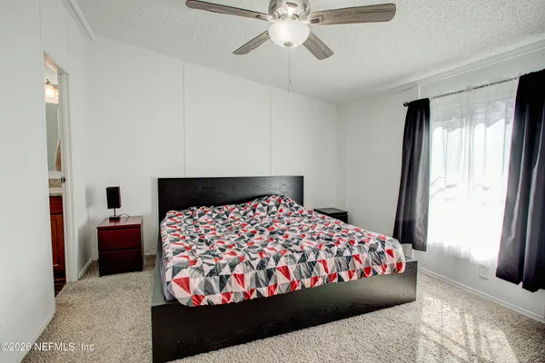 a bedroom with a large bed and a chandelier
