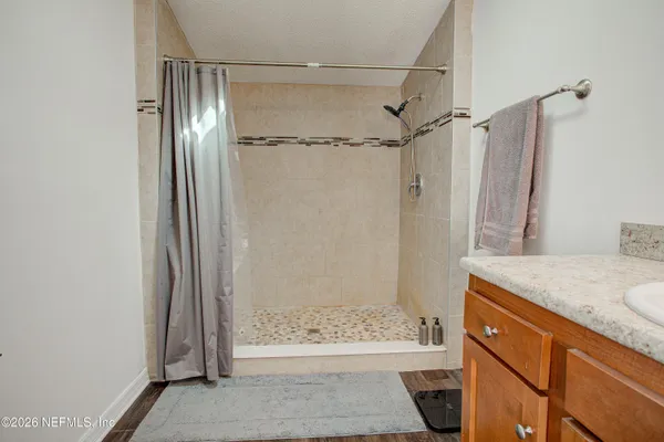 a bathroom with a granite countertop shower and a sink