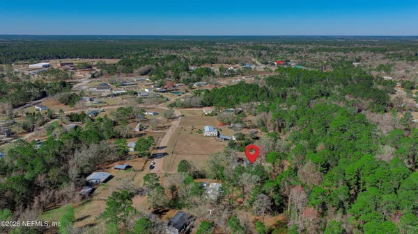 an aerial view of residential houses with outdoor space and trees