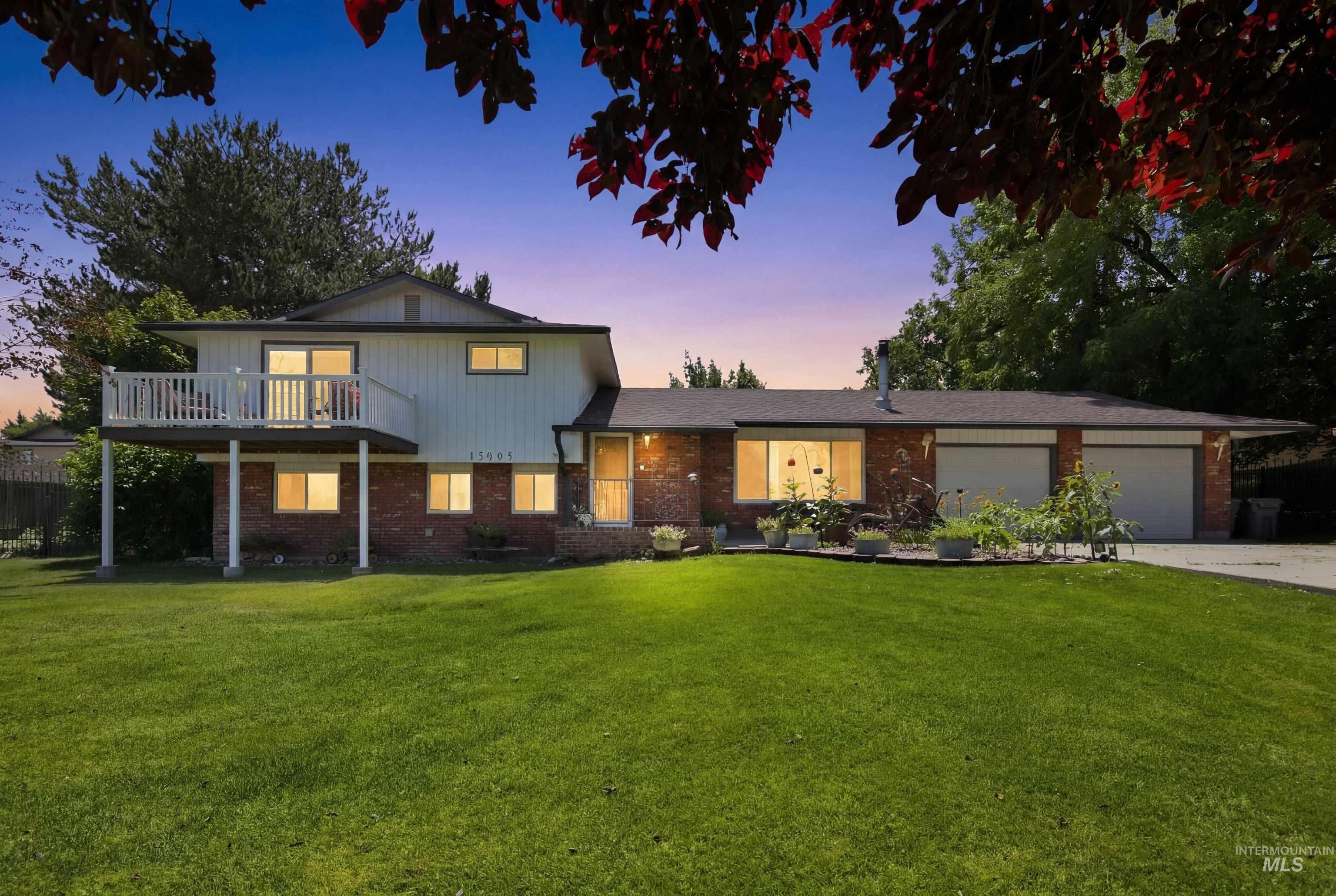 15095 David Street Caldwell, ID 83607 - Photo 1 of 39 Two-story residence featuring brick and siding facade, a front-facing balcony with white railing, and a multi-car garage