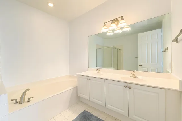 a bathroom with a sink a large mirror and a bathtub