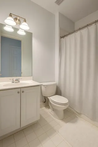 a bathroom with a sink a toilet and shower curtain