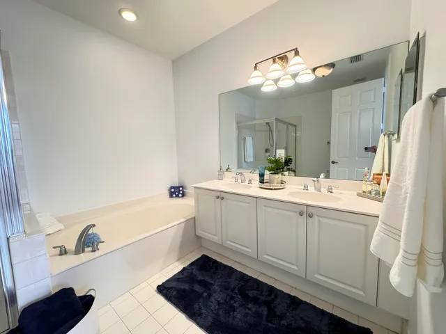 a bathroom with a tub sink and mirror
