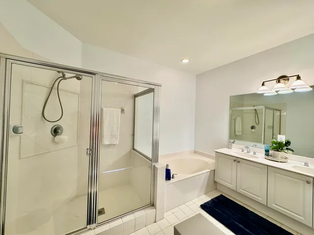 a bathroom with a double vanity sink mirror and shower